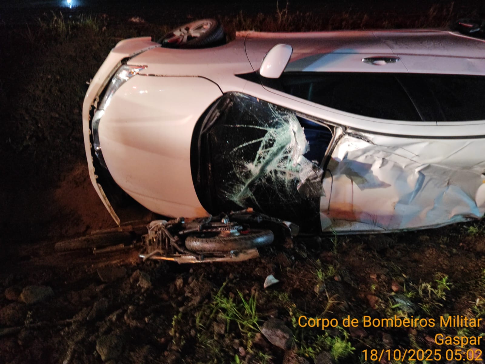 Condutora de moto tem ferimentos leves após carro cair em vala e capotar em cima de sua moto na BR 470 em Gaspar