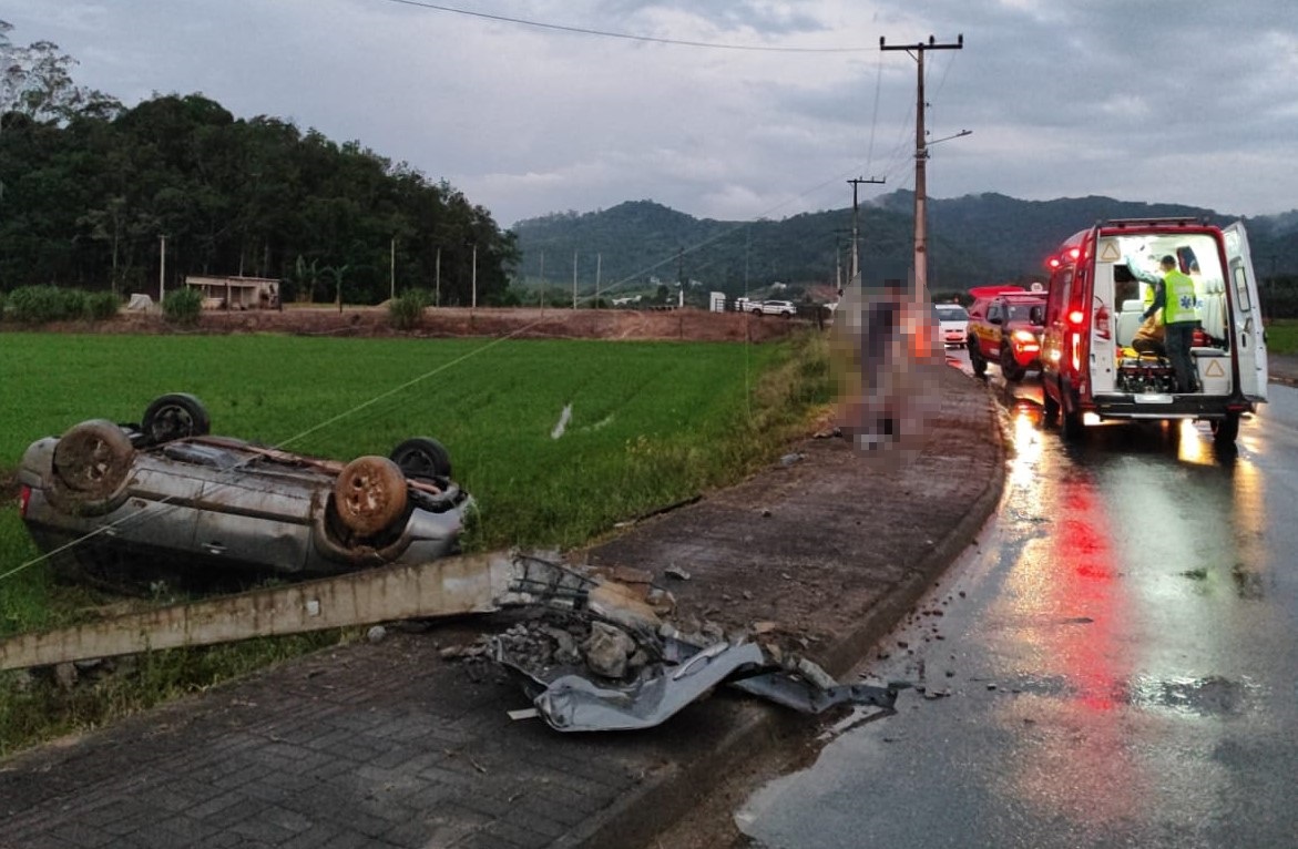 Mulher tem ferimentos leves após sair de pista, bater contra poste e capotar veículo, na rua Arthur Poffo, no bairro Santa Terezinha.
